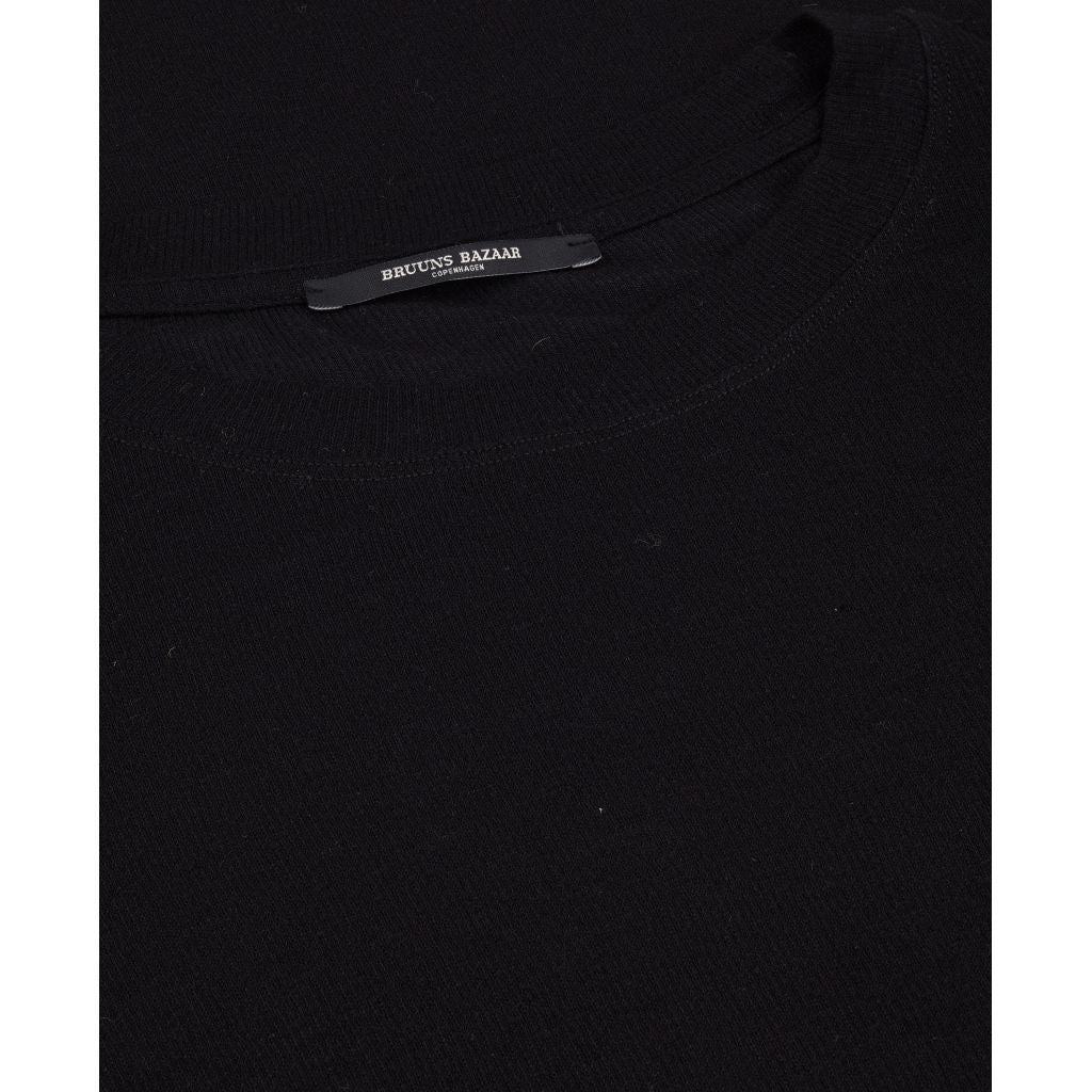 Angela bluse i sort fra Bruuns Bazaar er en lækker langærmet t-shirt med tætsiddende pasform. Den langærmet t-shirt har mange stylings muligheder. Style den med et par fede jeans og sneakers til hverdagsbrug eller en flot farverig nederdel og et par støvler eller stiletter til fest. 
